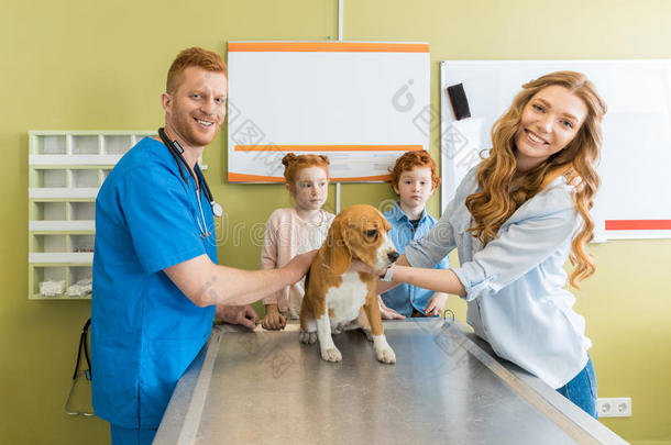 女人和她孩子们和他们的狗在兽医的医生