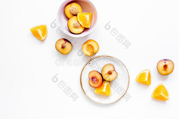 将切开桃子和桔子为异国的成果向盘子白色的背景