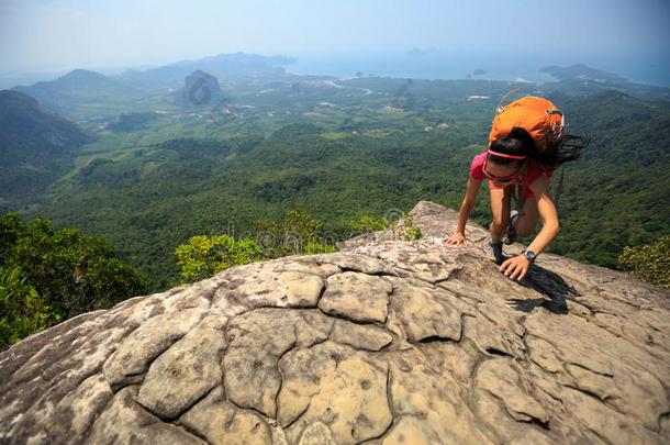 女人登山者攀登的岩石在山顶