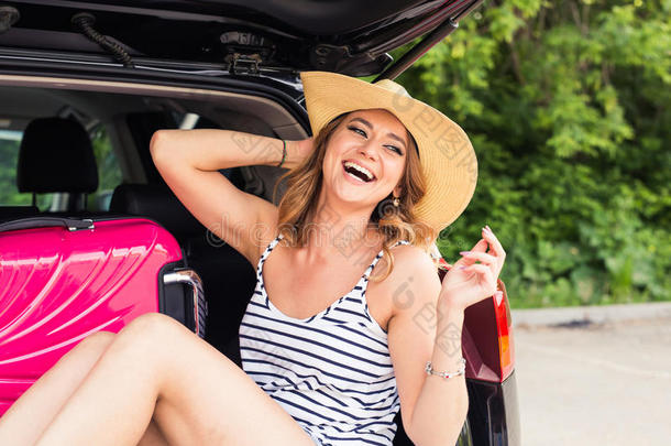 幸福的女人和行李采用汽车树干.旅行观念