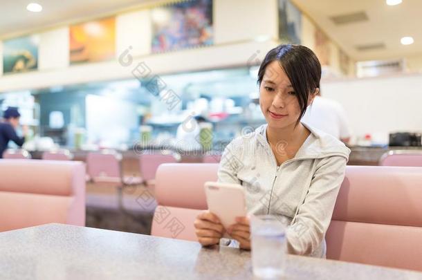女人使用关于可移动的电话采用日本人<strong>餐饮店</strong>