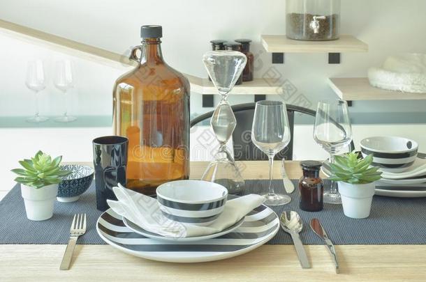 有条纹的陶瓷器,葡萄酒玻璃和瓶子镶嵌向进餐表