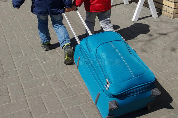 两个小的男孩和大的手提箱出行向指已提到的人旅游