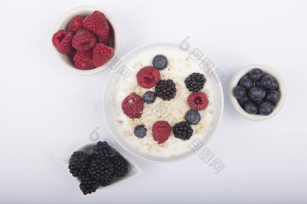 碗关于白色的酸奶和浆果和燕麦小薄片隔离的