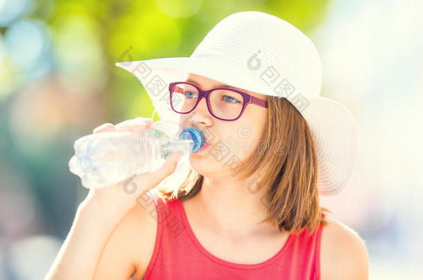 年幼的女孩喝饮料新鲜的水向一热的夏d一y