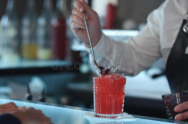 酒吧间销售酒精饮料的人装饰鸡尾酒红色的酒精的鸡尾酒和贝里