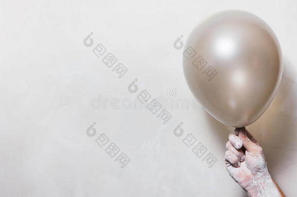 手采用灰泥和气球向白色的背景