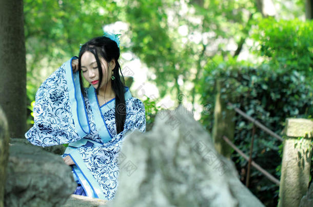 亚洲人中国人女人采用传统的蓝色和白色的汉服衣服,英语字母表的第16个字母