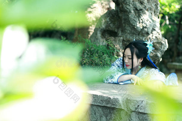 中国人女人采用传统的蓝色和白色的汉服衣服攀登oval卵形的