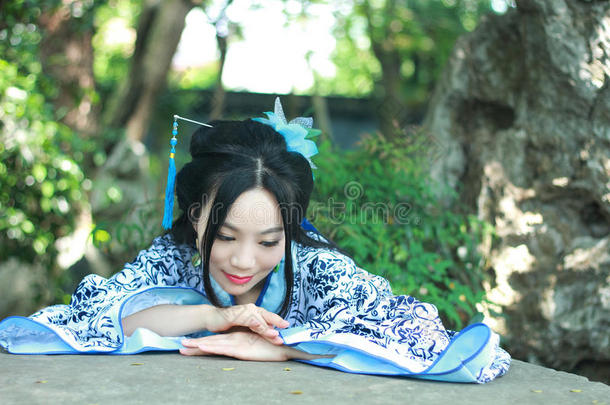 中国人女人采用传统的蓝色和白色的汉服衣服攀登oval卵形的