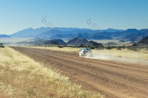 汽车操纵快的和灰尘云向沙漠路