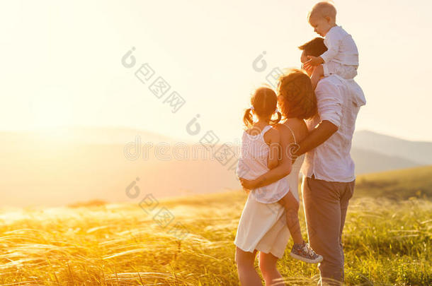 幸福的家庭:母亲,父亲,孩子们儿子和女儿向太阳