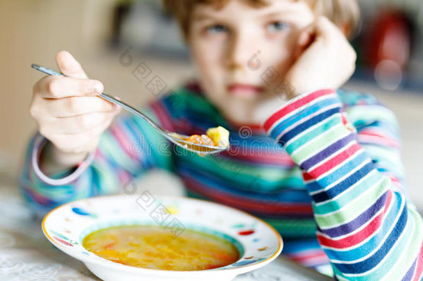 值得崇拜的小的学校男孩吃蔬菜汤室内的.