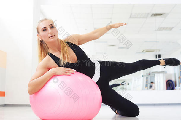 女人向健身球做面弯曲练习锻炼在健身房室内的