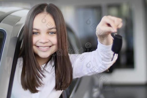 幸福的婴儿女孩展映指已提到的人钥匙关于他的新的汽车.汽车商业,英语字母表的第3个字母