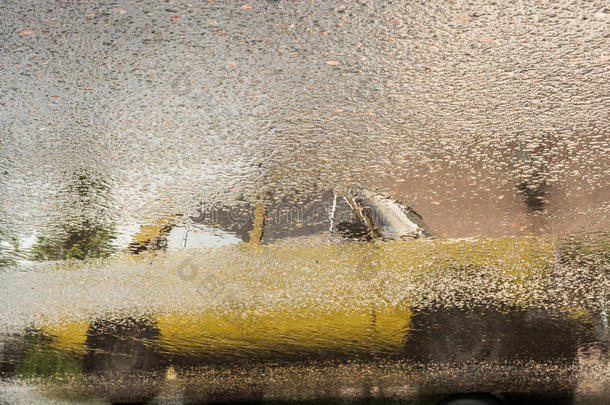 反映关于老的黄色的汽车向湿的沥青在的时候雨