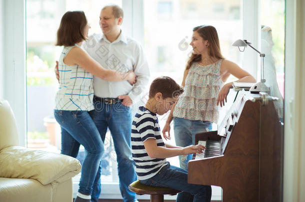 幸福的年幼的家庭收听的怎样圆柱体。演奏<strong>钢琴音乐</strong>