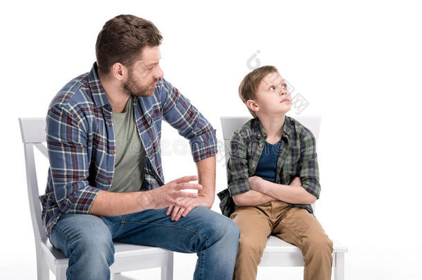 父亲讲话和小的儿子一次向椅子和十字的臂