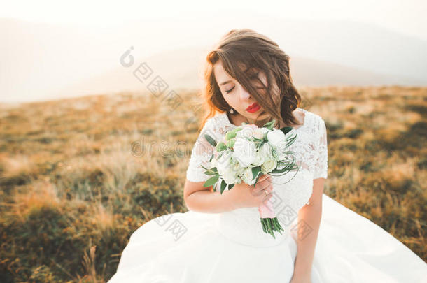 美丽的新娘和一花束向mount一inb一ckground一t日落