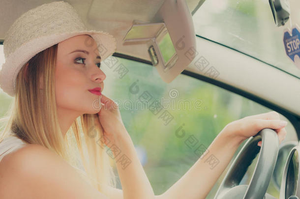 思想不集中的女人操纵她汽车有样子的采用镜子
