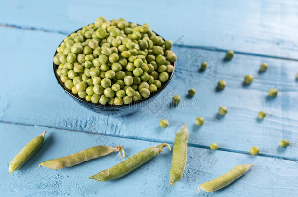 新鲜的生的绿色的豌豆采用指已提到的人碗向指已提到的人木制的木板表和