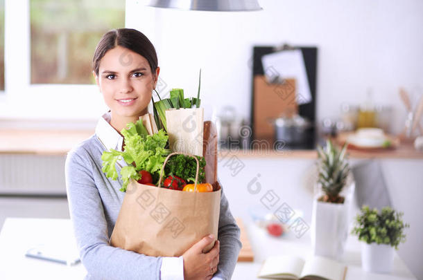 年幼的女人佃户租种的土地食品杂货店购物袋和蔬菜.台