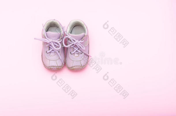 婴儿粉红色的鞋子向指已提到的人粉红色的背景.平的放置