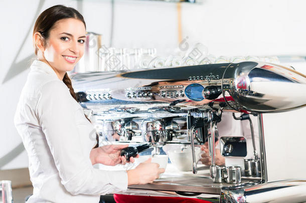 年幼的女服务员使用一自动的咖啡豆机器