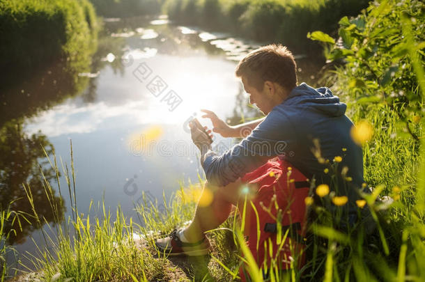 年幼的男人一次紧接在后的向河和可移动的电话和享有我