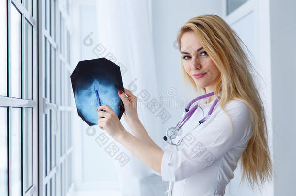 年幼的医学的医生女人弄尖向字母x-射线