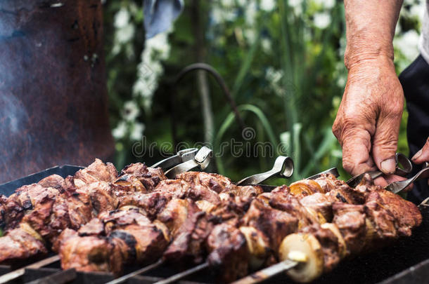 猪肉希什河烤腌羊肉串和洋葱向串肉扦手关于男人