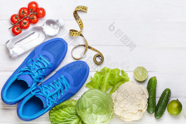 新鲜的健康的蔬菜,旅游鞋向白色的木材背景.