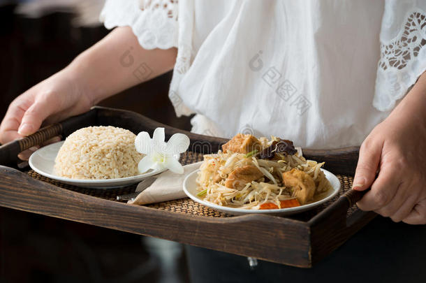 厨师服务棕色的稻和素食者食物.