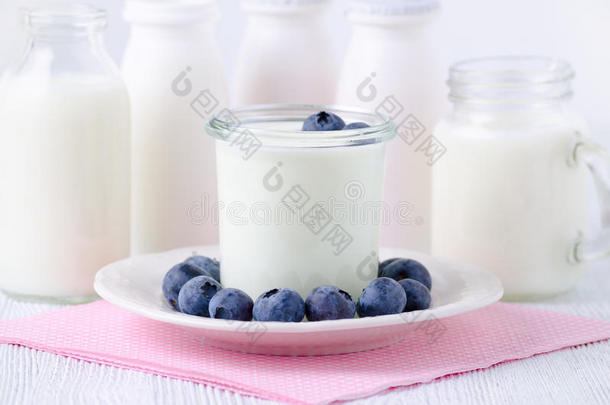 一杯子关于酸奶和蓝莓和不同的瓶子关于酸奶