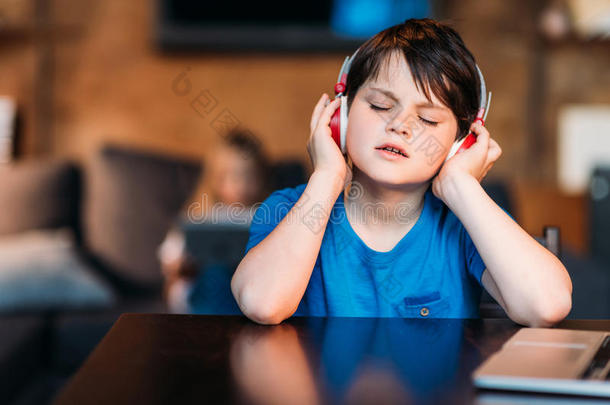 集中的小的男孩收听的音乐采用耳机