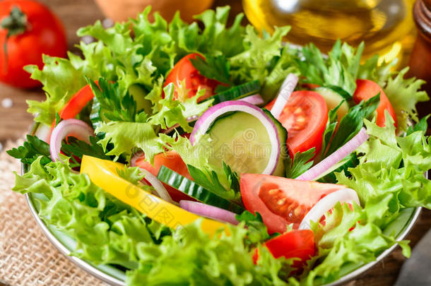新鲜的蔬菜沙拉和绿叶蔬菜向木制的表.