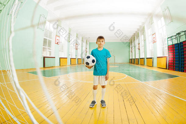 男孩起立和足球球采用学校健身房