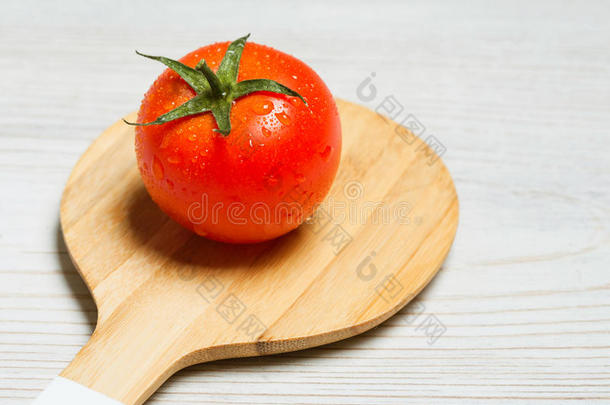番茄和木制的餐具向白色的木制的背景