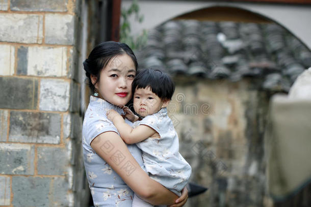 家庭乐趣时间,中国人女人和婴儿采用旗袍享有自由的