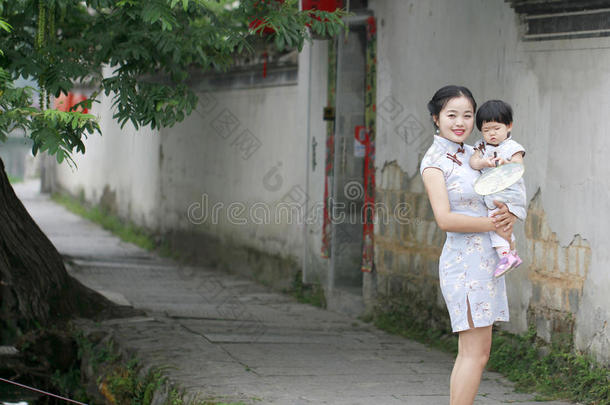 家庭乐趣时间,中国人女人和婴儿采用旗袍享有自由的