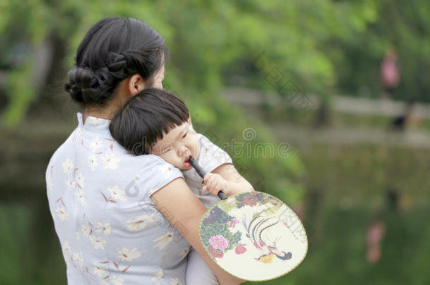 家庭乐趣时间,中国人女人和婴儿女孩采用旗袍享有