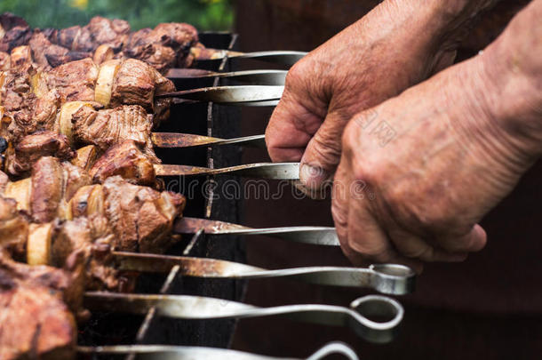 猪肉希什河烤腌羊肉串和洋葱向串肉扦手关于男人
