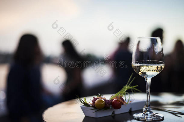 玻璃关于白色的葡萄酒和美食家食物塔帕纤维布小吃在外面