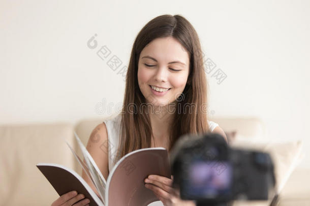 微笑的青少年女孩和书记录视频博客