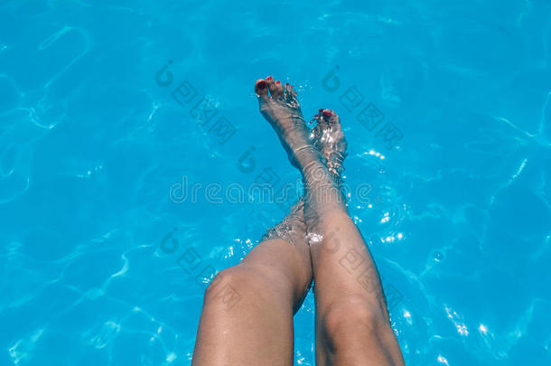 美丽的女孩令人轻松的她脚采用水池水