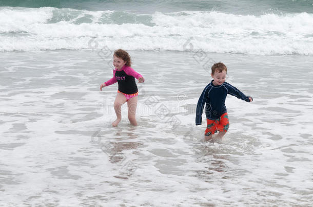年幼的漂亮的小的男孩和女孩演奏在指已提到的人海滨跑步采用