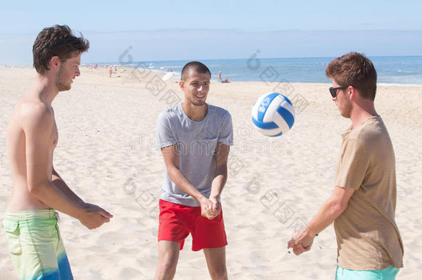 朋友演奏海滩排球在海滩