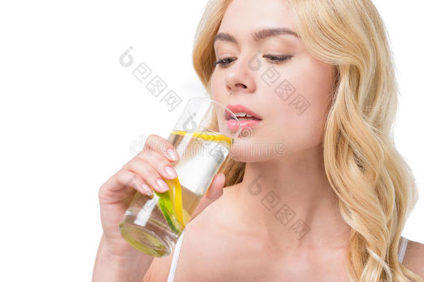 年幼的高加索人女人喝饮料水和柠檬从玻璃
