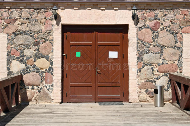 钢投票盒为残端和垃圾在近处棕色的木制的门.