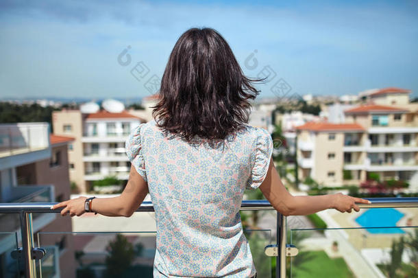 女人享有城市风光照片起立向屋顶